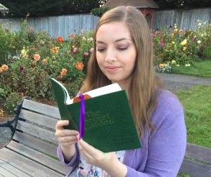 A photo of the author holding a book sitting on a bench